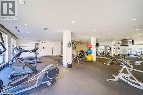 Fitness center featuring a variety of cardio and strength training equipment, rubberized flooring, recessed lighting, and expansive windows - 40 Esplanade Lane Unit# 614, Grimsby, ON 