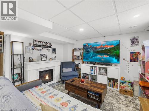 Finished basement recreation area featuring a fireplace with a white mantel, recessed lighting, and a drop ceiling - 420 Waverly Street, Hamilton, ON 