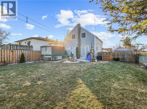 Expansive backyard featuring a manicured lawn, a full privacy fence, and a storage shed - 420 Waverly Street, Hamilton, ON 