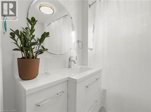 Contemporary bathroom vanity featuring a rectangular undermount sink, chrome faucet, and integrated white countertop - 420 Waverly Street, Hamilton, ON 