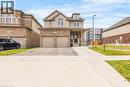 Two-story residence featuring a brick and siding exterior, a covered front porch, and a two-car garage with individual doors - 417 Rivertrail Avenue, Kitchener, ON 