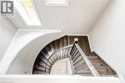 Architectural staircase featuring dark wood treads and a coordinating banister - 417 Rivertrail Avenue, Kitchener, ON 