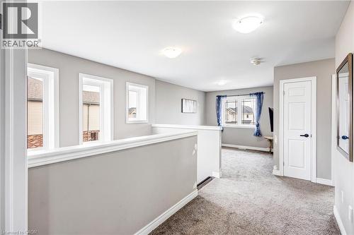 Upper-level landing featuring a white railing and neutral gray walls - 417 Rivertrail Avenue, Kitchener, ON 
