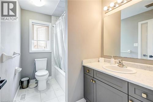 Bathroom featuring a vanity with a light-colored countertop, an integrated sink, and gray cabinetry with brass hardware - 417 Rivertrail Avenue, Kitchener, ON 