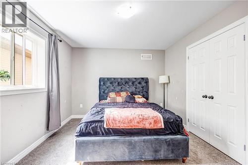 Bedroom featuring neutral wall paint, carpet flooring, a single window, and white bi-fold closet doors - 417 Rivertrail Avenue, Kitchener, ON 