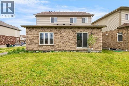 Rear exterior featuring a brick first level, siding on the second level, multiple windows, and a sliding glass door - 417 Rivertrail Avenue, Kitchener, ON 