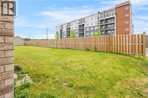 Expansive green lawn outlined by a light wood privacy fence - 417 Rivertrail Avenue, Kitchener, ON 