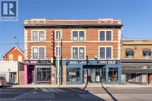 Brick facade building featuring multiple storefronts and upper-level windows - 657 Barton Street E Unit# 302, Hamilton, ON 