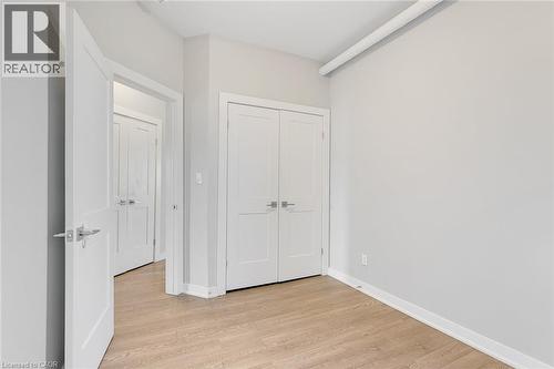 Room featuring wood-finish flooring, light grey walls, and white trim - 657 Barton Street E Unit# 302, Hamilton, ON 
