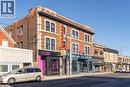 Brick commercial building featuring stone trim accents and ground-level retail storefronts with large display windows - 657 Barton Street E Unit# 302, Hamilton, ON 