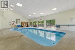 Indoor swimming pool with light blue lining, integrated spa, and concrete decking - 