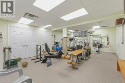 Carpeted room featuring drop ceiling with recessed lighting, light-toned walls, and multiple panel doors - 