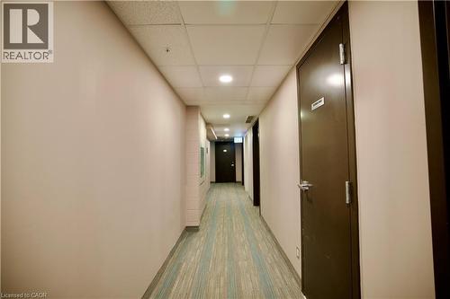 Hallway featuring light beige walls, a drop ceiling with recessed lighting, and patterned carpet flooring - 246 Lester Street Unit# 306, Waterloo, ON 