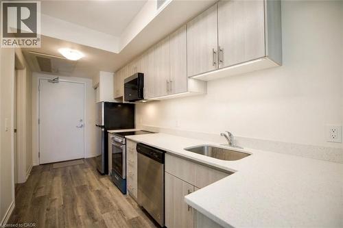 Kitchen featuring wood-finish flooring, light wood-grain cabinetry, light-toned countertops, and stainless steel appliances - 246 Lester Street Unit# 306, Waterloo, ON 