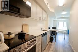 Compact kitchen featuring light wood-finish cabinetry and light-toned countertops - 