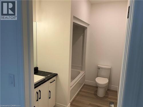 Bathroom with vanity, wood finished floors, toilet, baseboards, and shower / tub combination - 207 Arden Crescent Unit# Upper Level, Mitchell, ON 
