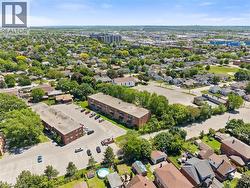 Aerial perspective showcasing two brick-clad multi-story buildings with extensive paved parking areas - 