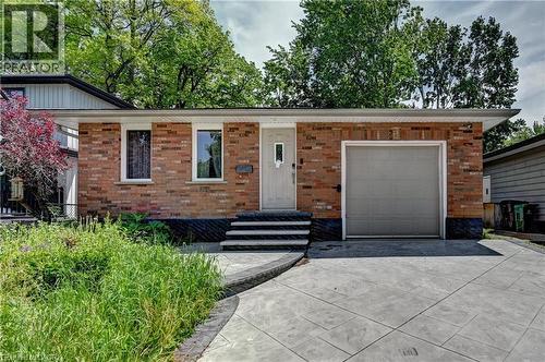 Brick facade residence featuring a front entry with three steps, an attached single-car garage, and a stamped concrete driveway - 525 Fallingbrook Drive, Waterloo, ON 