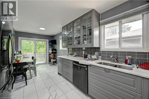 Contemporary kitchen featuring gray cabinetry, light countertops, and a subway tile backsplash - 525 Fallingbrook Drive, Waterloo, ON 