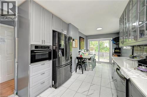 Contemporary kitchen featuring light gray cabinetry, integrated stainless steel appliances, and a built-in oven - 525 Fallingbrook Drive, Waterloo, ON 