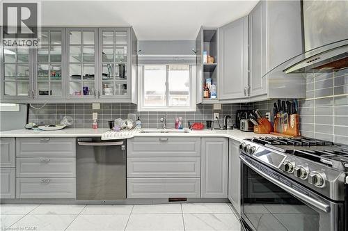 Contemporary kitchen featuring light gray cabinetry, quartz-finish countertops, and a subway tile backsplash - 525 Fallingbrook Drive, Waterloo, ON 