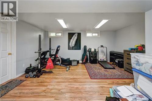 Versatile room with wood-finish flooring, light grey walls, and two horizontal windows - 525 Fallingbrook Drive, Waterloo, ON 