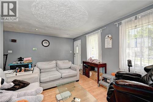 Living space featuring wood-finish flooring, two large windows, a white entry door, recessed lighting, and a textured ceiling - 525 Fallingbrook Drive, Waterloo, ON 