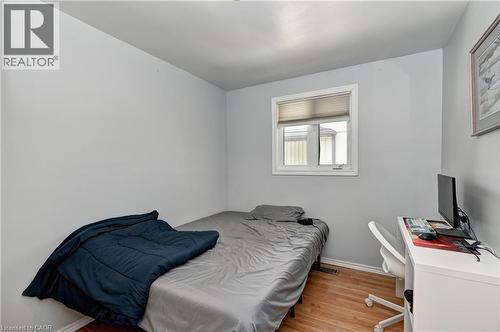 Room featuring light gray walls, wood-finish flooring, and a single window with white trim - 525 Fallingbrook Drive, Waterloo, ON 