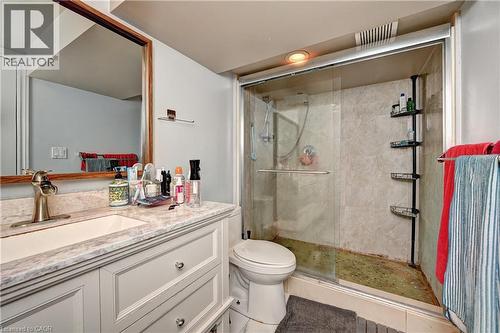 Bathroom featuring a light-colored vanity with a built-in sink, a framed mirror, and a glass-enclosed shower with tiled walls - 525 Fallingbrook Drive, Waterloo, ON 