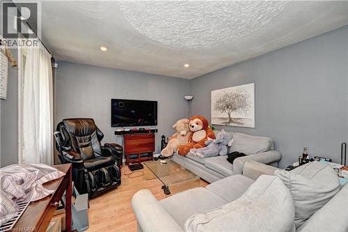 Recessed lighting illuminates the room with wood-finish flooring and a textured ceiling - 525 Fallingbrook Drive, Waterloo, ON 