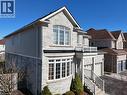 View of front facade featuring stone siding, an attached garage, a balcony, and asphalt driveway - 512 Terrington Crescent, Kitchener, ON 