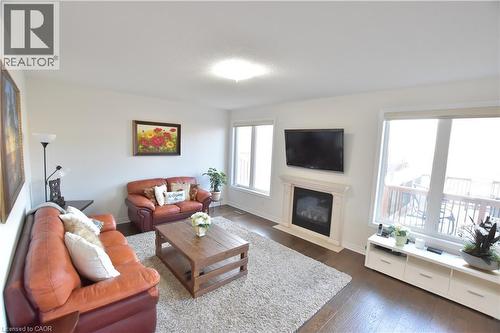 Living area featuring dark wood finished floors and a fireplace with flush hearth - 512 Terrington Crescent, Kitchener, ON 