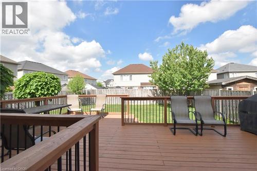Spacious wood-finish deck with dark railings, providing an elevated exterior living area - 512 Terrington Crescent, Kitchener, ON 