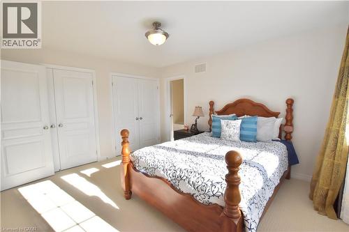 Bedroom featuring two closets and light carpet - 512 Terrington Crescent, Kitchener, ON 