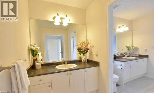 Full bath featuring two vanities, light tile patterned floors, and suspended lighting - 512 Terrington Crescent, Kitchener, ON 