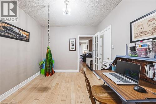 Bright room featuring light-toned wood-finish flooring and white baseboards - 70 Webster Road, Hamilton, ON 