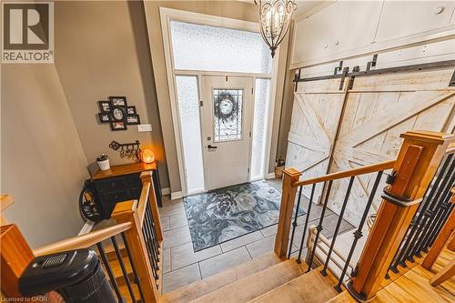 Foyer featuring a decorative front entry door with transom and sidelight windows, tile flooring, and a pair of barn doors - 70 Webster Road, Hamilton, ON 