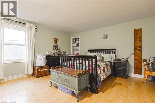 Bright room featuring light wood-finish flooring, a large window with white trim, and light green walls - 70 Webster Road, Hamilton, ON 