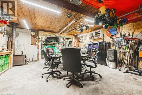 Utility space featuring a wood-panel ceiling, concrete flooring, and bright overhead lighting - 70 Webster Road, Hamilton, ON 