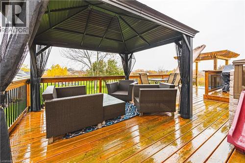 Spacious outdoor deck featuring rich wood flooring and a large, covered gazebo with dark privacy screens - 70 Webster Road, Hamilton, ON 