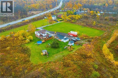 Expansive property featuring a two-story residence with a rear deck, multiple outbuildings, and a large grassy area - 70 Webster Road, Hamilton, ON 