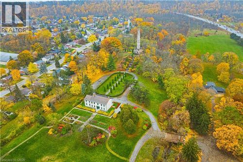 Expansive property featuring a white colonial-style residence, formal gardens, manicured green spaces, and mature trees - 70 Webster Road, Hamilton, ON 