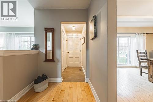 Light wood-finish flooring extending into an open living area with a large window - 70 Webster Road, Hamilton, ON 