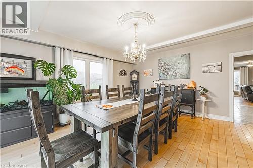 Dining area featuring light wood-finish flooring, a decorative ceiling medallion with a chandelier, and a large window - 70 Webster Road, Hamilton, ON 