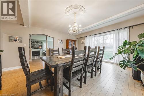 Dining area featuring light wood-finish flooring, a decorative ceiling medallion, and a chandelier with crystal accents - 70 Webster Road, Hamilton, ON 
