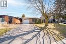 Brick facade residence featuring a white garage door, dark window frames, and a paved driveway - 19 Glen Forest Drive, Hamilton, ON 