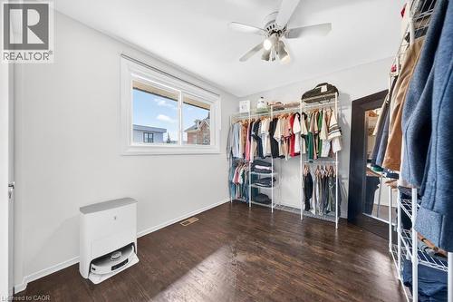 Room with wood-finish flooring, a white ceiling fan with integrated lighting, and a large window - 19 Glen Forest Drive, Hamilton, ON 