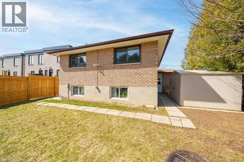 Rear exterior featuring brick siding, a brown roofline, and multiple windows - 19 Glen Forest Drive, Hamilton, ON 