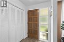 Entryway featuring a paneled wood door with a sidelight, white louvered bifold closet doors, and patterned floor tile - 1083 Melton Drive, Mississauga, ON 