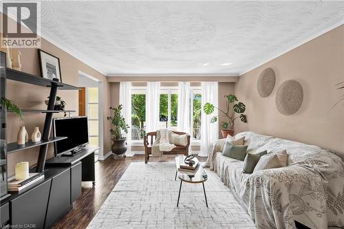 Spacious living area featuring wood-finish flooring, a decorative textured ceiling, and crown molding - 1083 Melton Drive, Mississauga, ON 